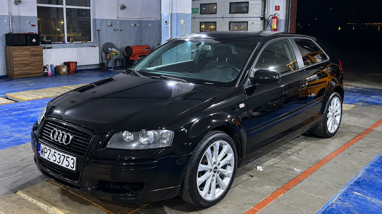 Czarne Audi w warsztacie nocą