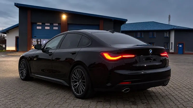 Czarne BMW Gran Coupe o zmierzchu przed halą